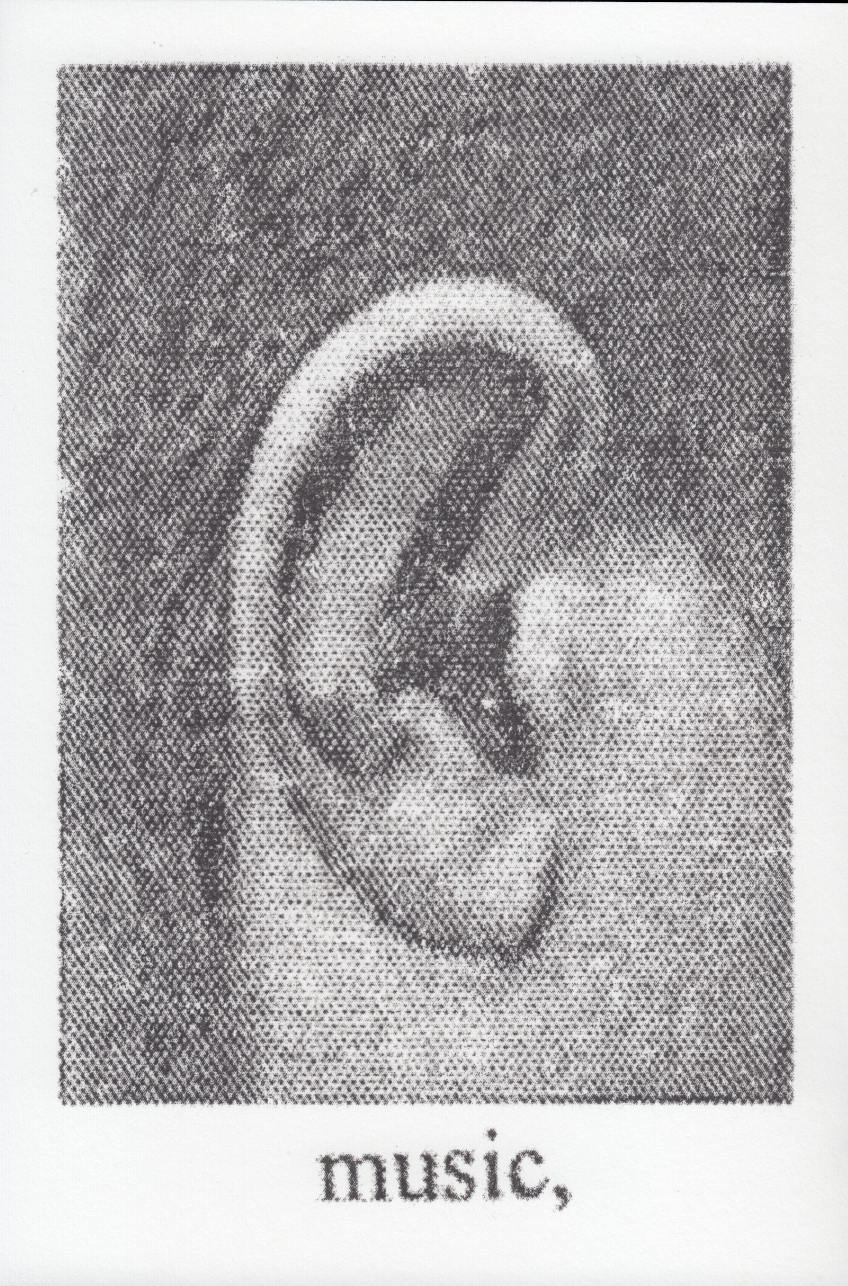 monochrome photograph of an ear above text that reads music printed on white paper