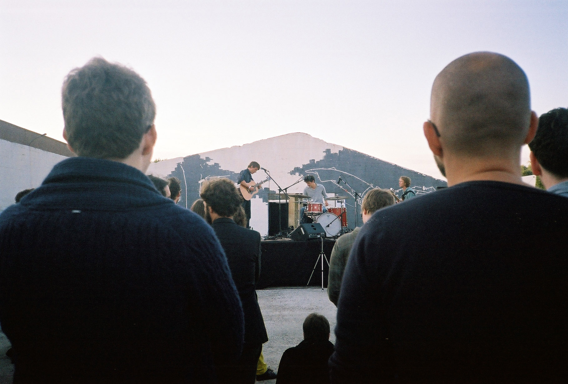 view through the heads of a crowd to a band playing on stage