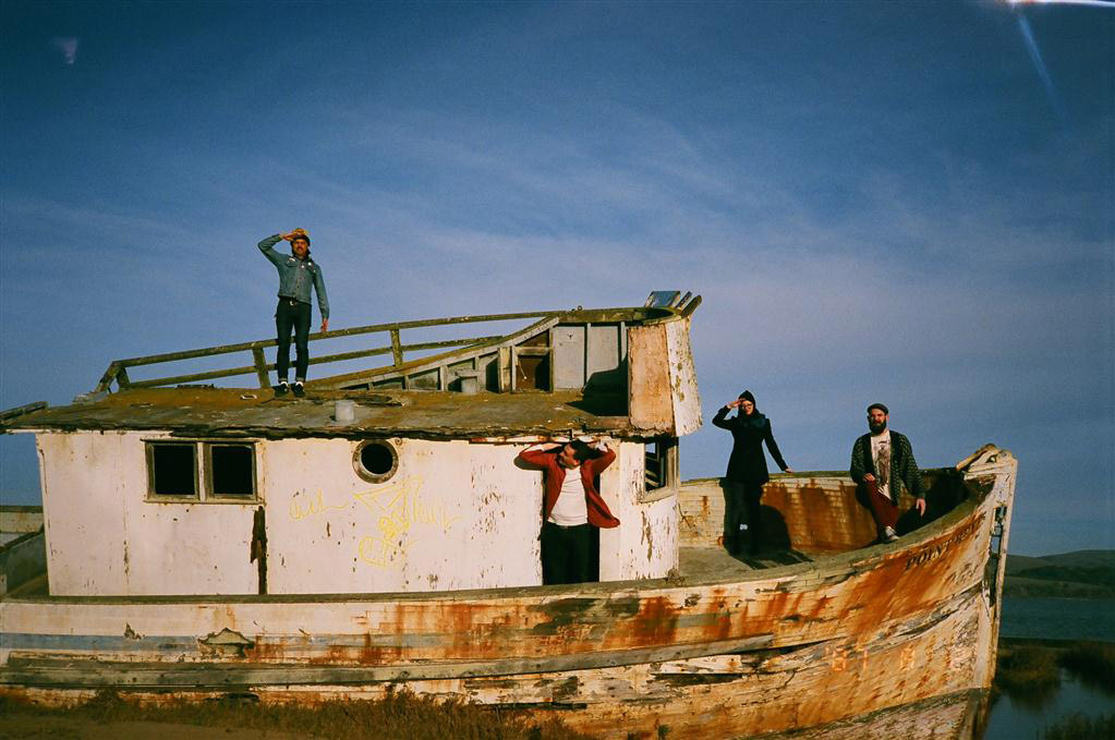 group of people posing on small shipwrecked boat
