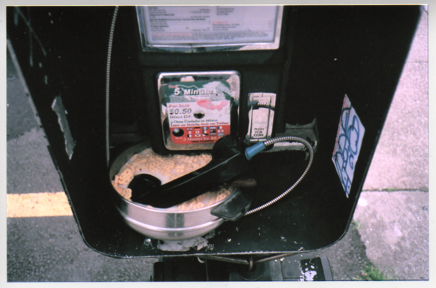 phone receiver inside bowl of cereal with milk inside payphone shelter