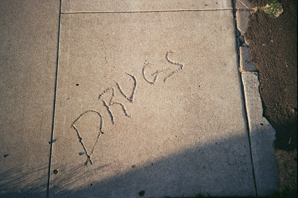 the word drugs scrawled into cement