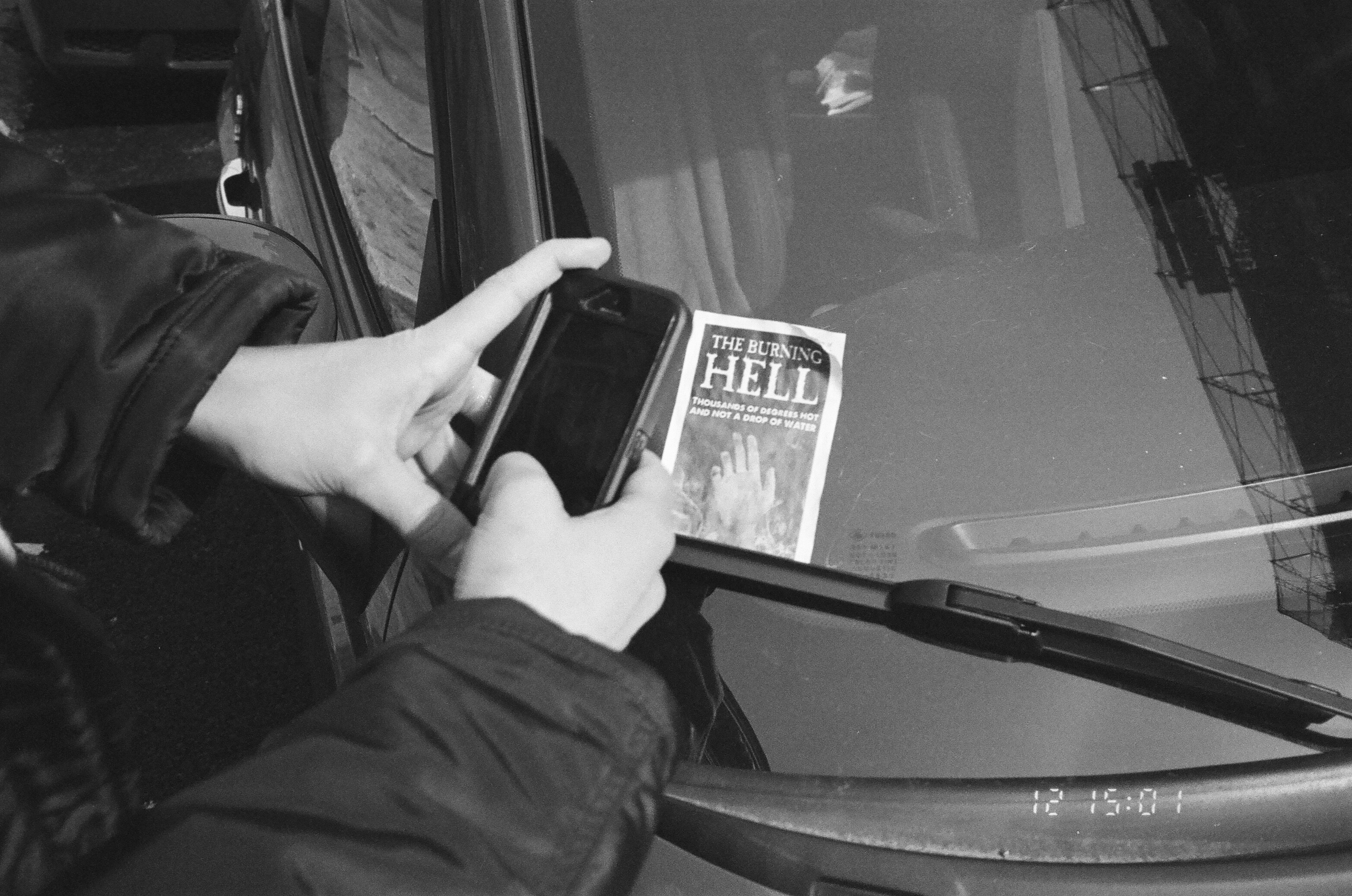 someone takes a photo of a religious pamphlet let on car with their iphone