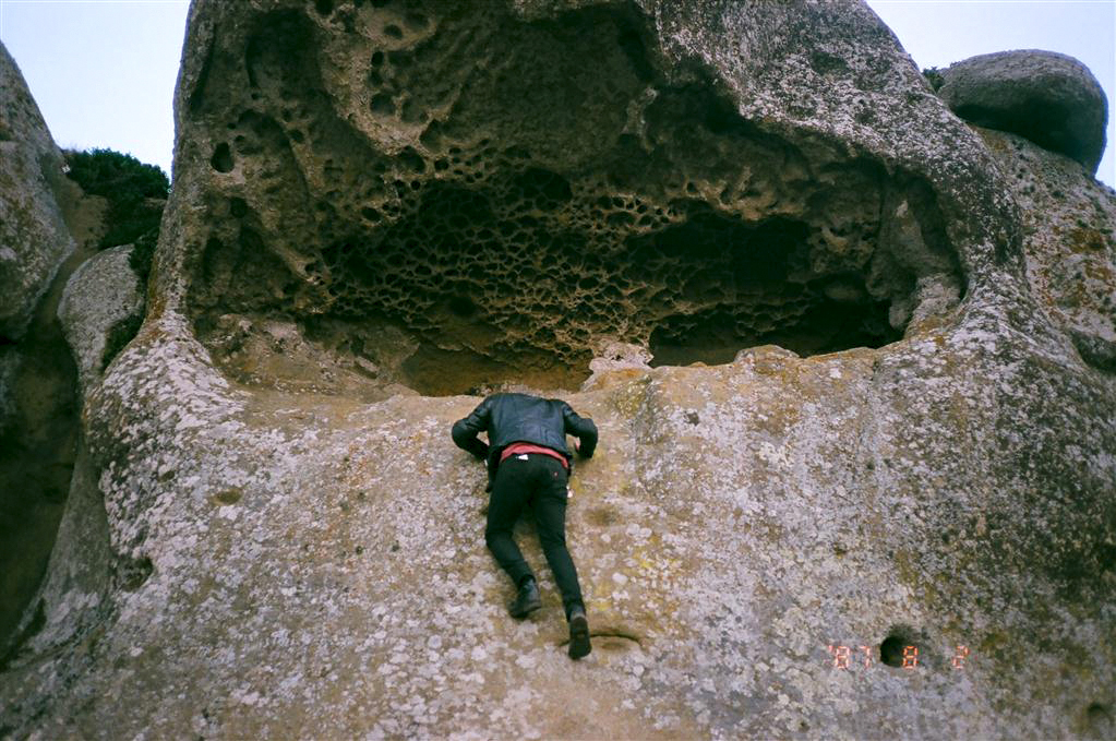 person climbing a giant rock