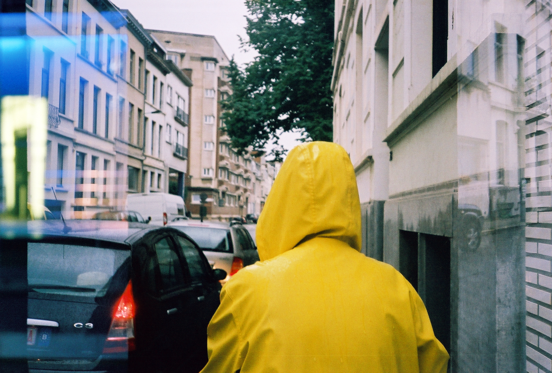 the back of a person's head who is wearing yellow raincoat hood
