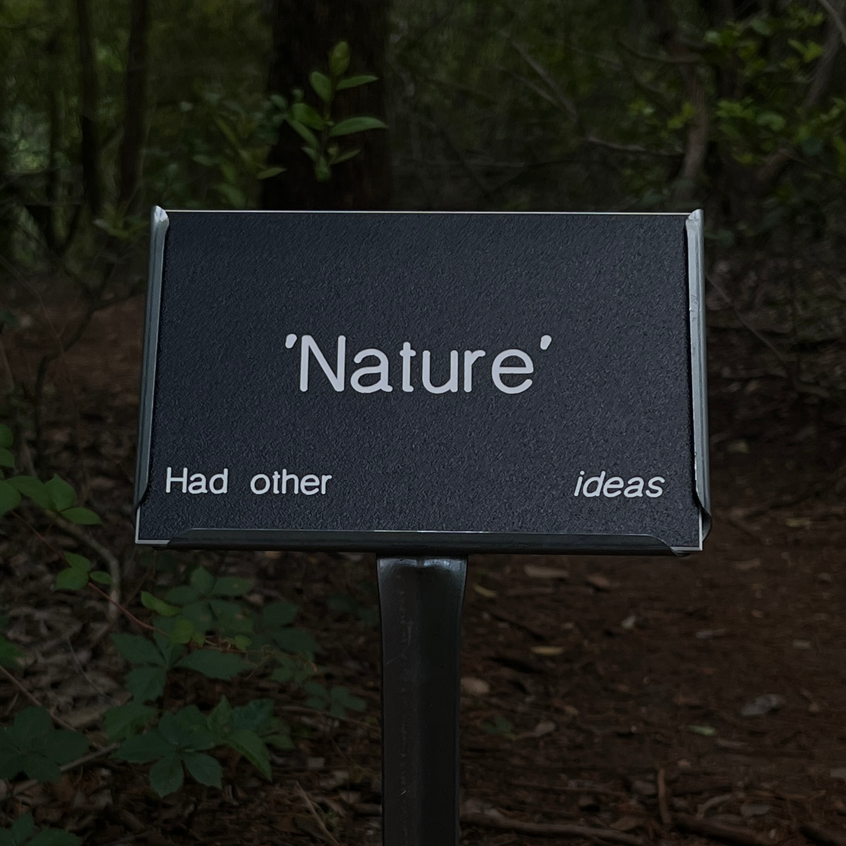 botanical sign along wooded footpath reads nature had other ideas