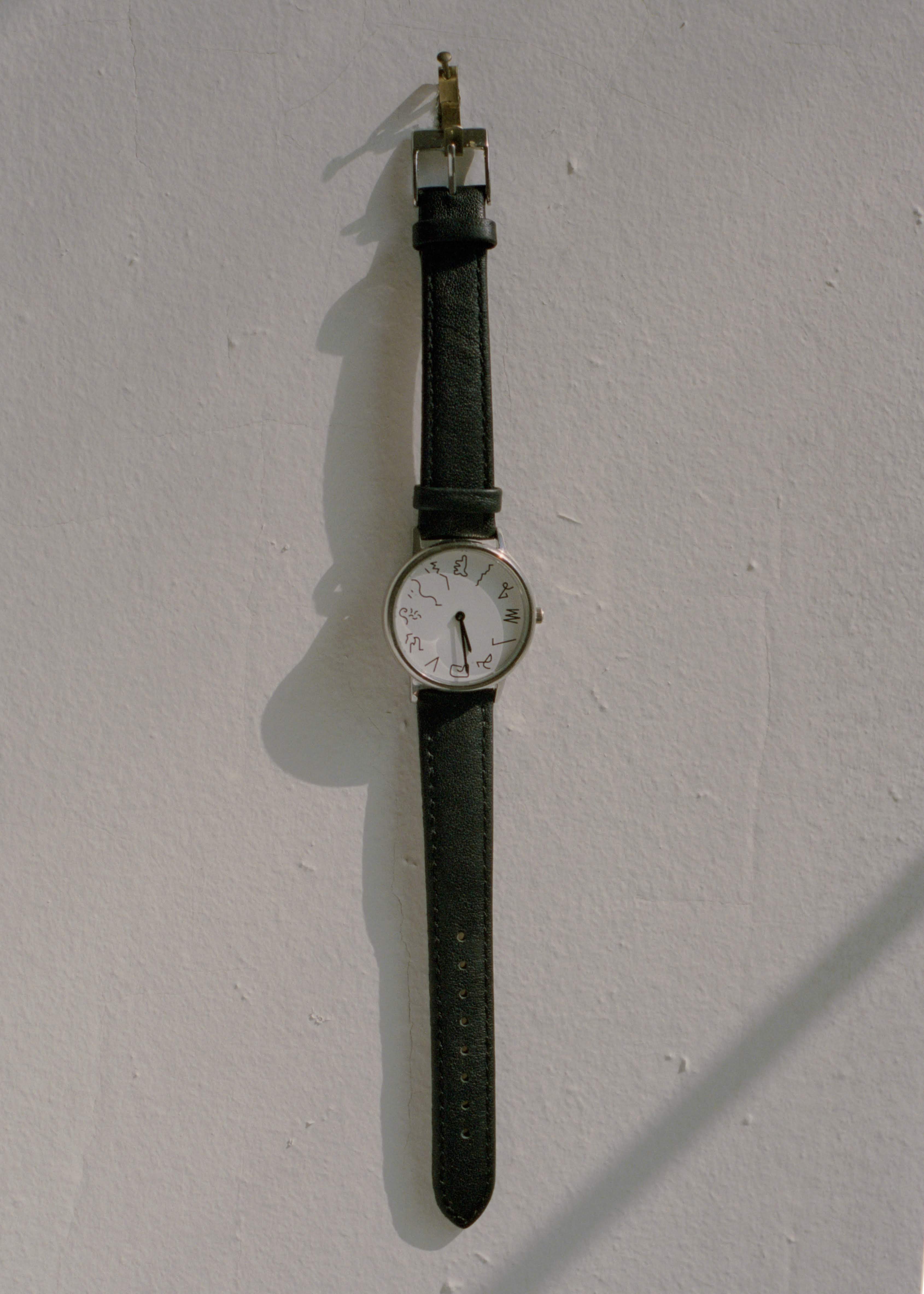 watch with squiggle lines instead of numbers hangs on wall